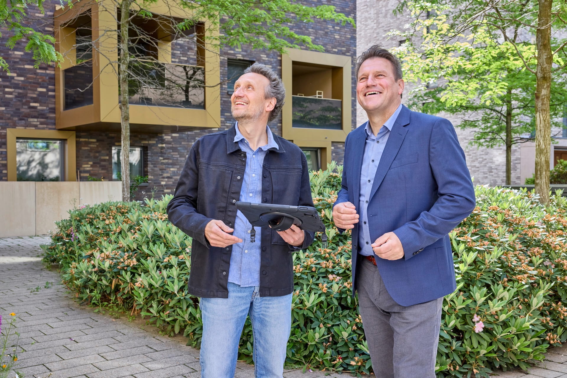 Gundlach Bauunternehmen Leitung zusammen mit einem Architekten im Innenhof des VIER